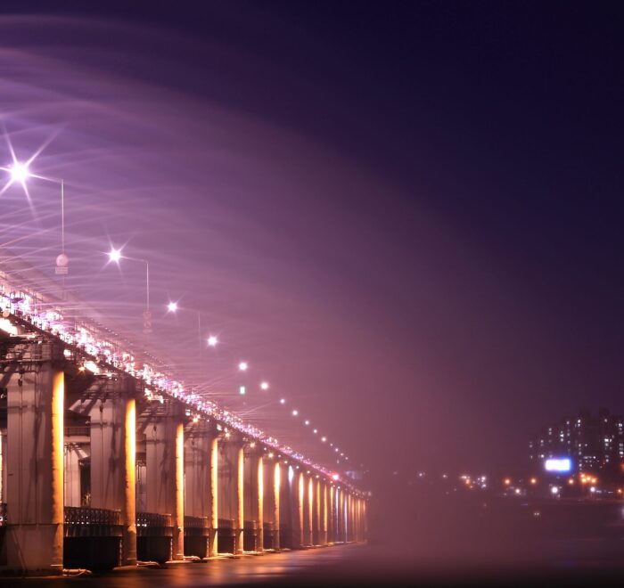 Night view of an illuminated bridge and city skyline, showcasing vibrant lights and urban architecture. 汉江野餐团, 盘浦汉江公园野餐垫, Some Sevit夜景, 彩虹喷泉表演, 便利店美食组合, 반포 한강공원 피크닉 매트, 세빛섬 야경, 무지개 분수 쇼, 편의점 꿀조합 미식, Han River Picnic Tour, Banpo Park picnic mat, Some Sevit night view, Rainbow Fountain show, convenience store spread, 盤浦漢江公園野餐墊, 漢江野餐團, 世貌島夜景, 彩虹噴泉表演, 便利商店美食組合