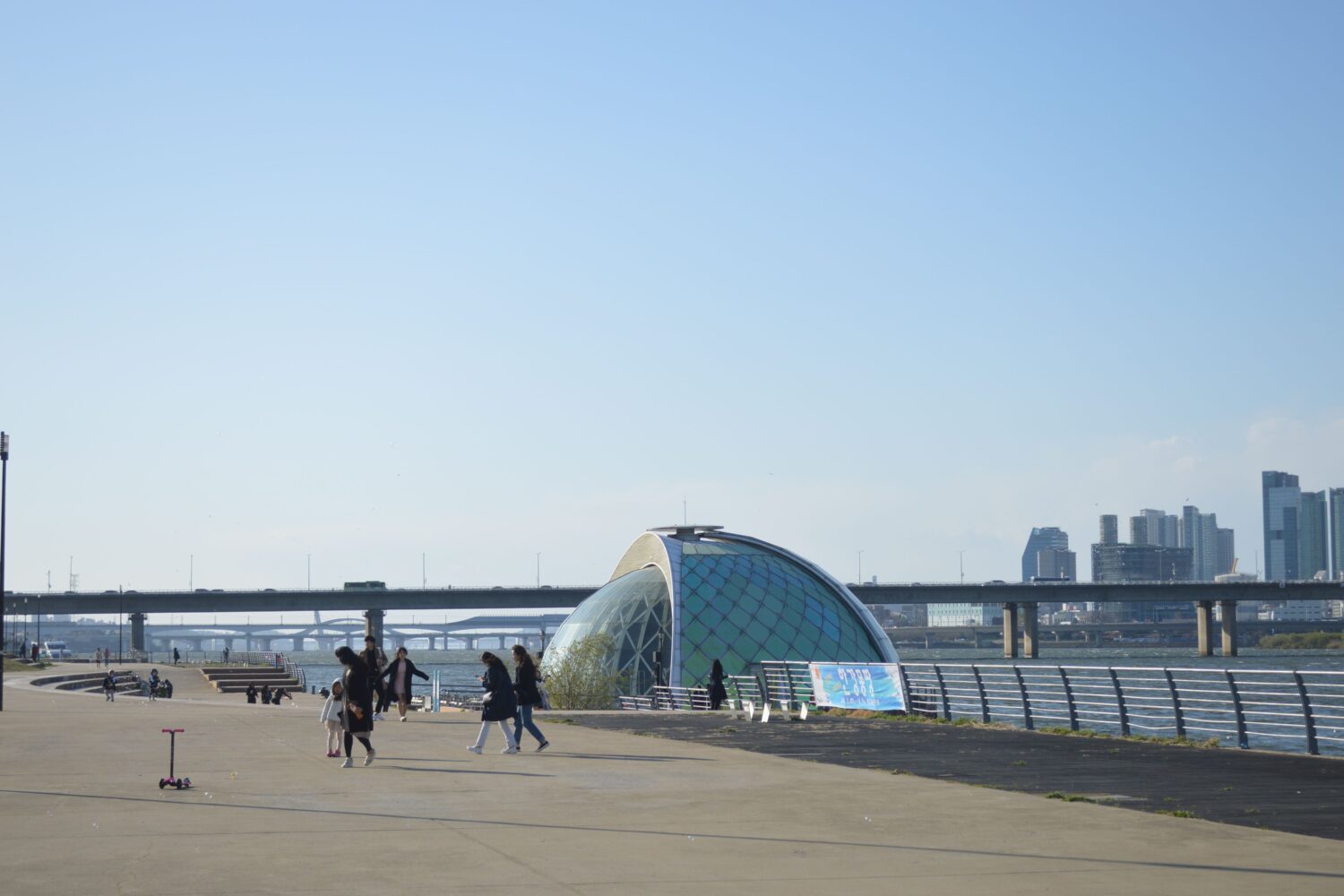 Scenic urban view featuring a unique glass dome and city skyline under clear blue sky.